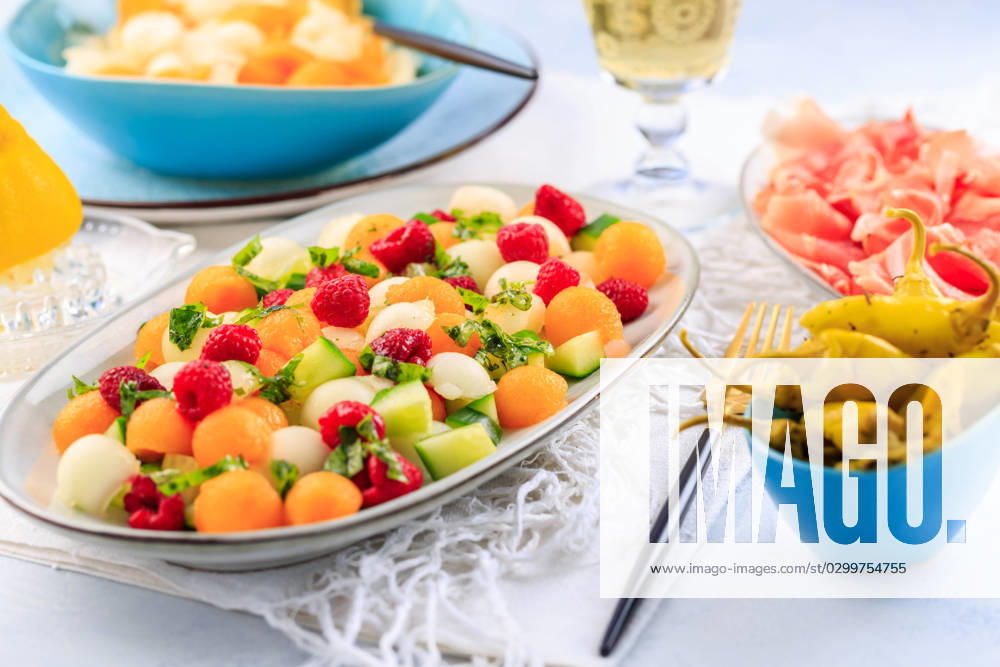 Summer light food. Cucumber and melon salad with raspberries and Prosciutto and pickled hot peppers Summer light food. Cucumber and melon salad with raspberries and Prosciutto and pickled hot peppers