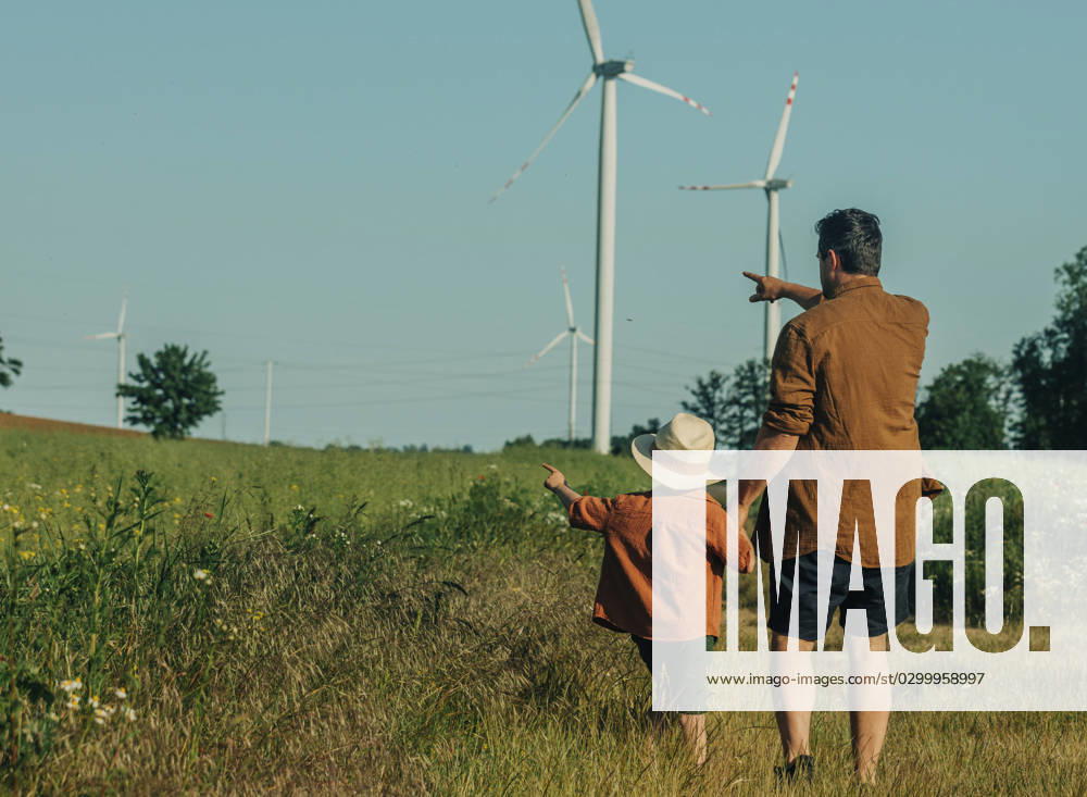 Father and son gesturing towards wind turbines at field model released, Symbolfoto, VSNF01080