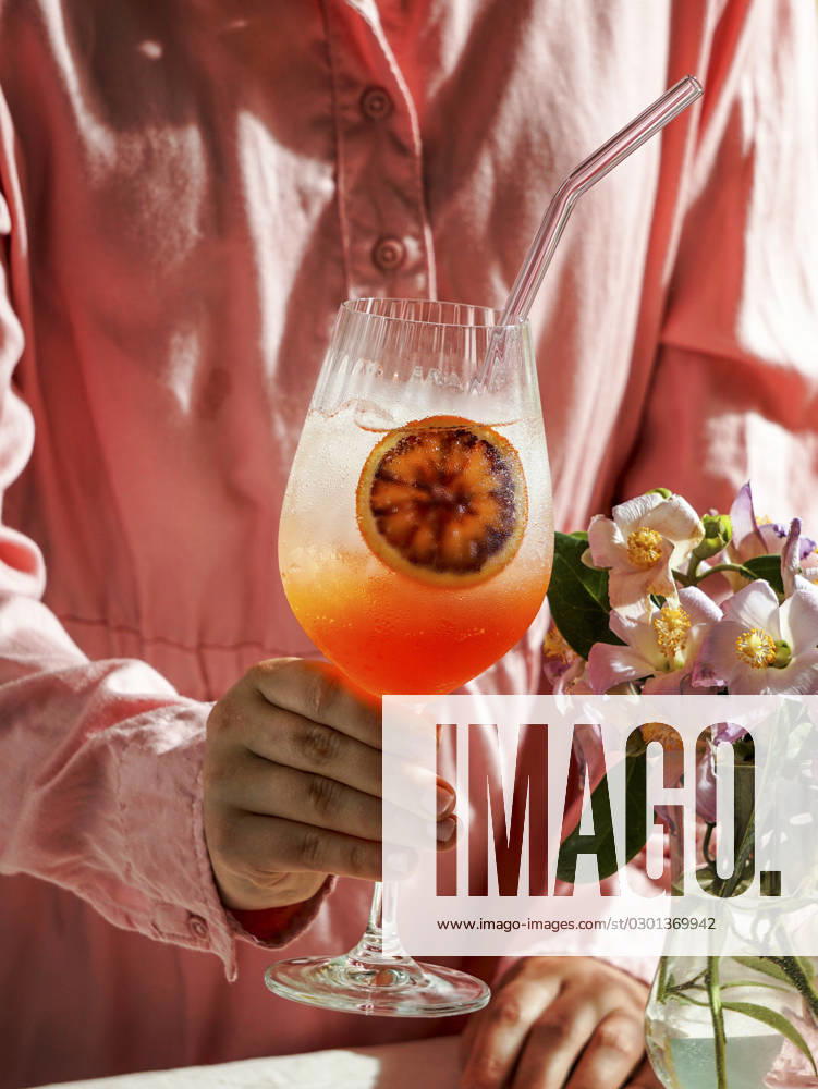 Aperol spritz cocktail, on a pale pink linen tablecloth, shadows, sunlight, summer drink in glass aperol spritz cocktail, on a pale pink linen tablecloth, shadows, sunlight, summer drink in glass