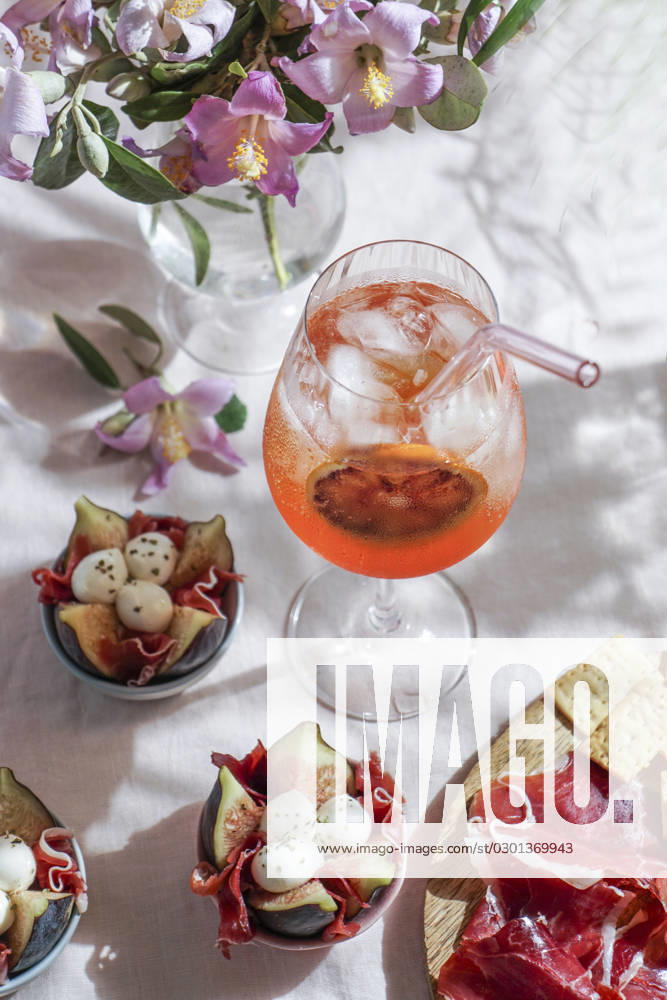 Aperol spritz cocktail, on a pale pink linen tablecloth, shadows, sunlight, summer drink in glass aperol spritz cocktail, on a pale pink linen tablecloth, shadows, sunlight, summer drink in glass