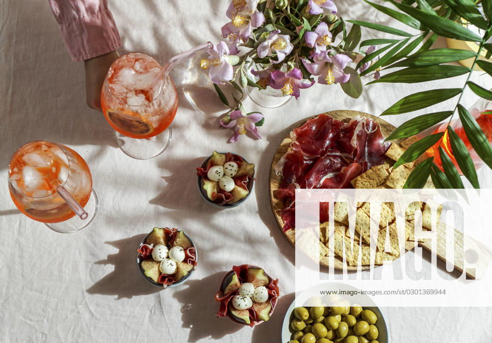 Aperol spritz cocktail, on a pale pink linen tablecloth, shadows, sunlight, summer drink in glass aperol spritz cocktail, on a pale pink linen tablecloth, shadows, sunlight, summer drink in glass