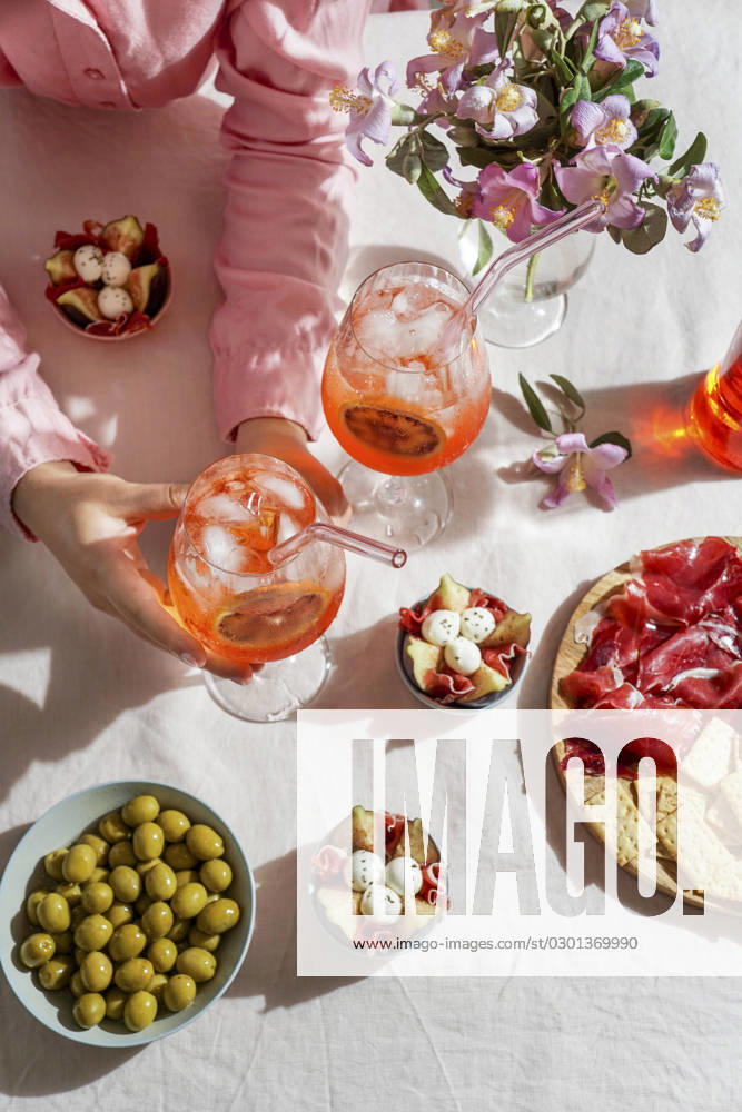 Aperol spritz cocktail, on a pale pink linen tablecloth, shadows, sunlight, summer drink in glass aperol spritz cocktail, on a pale pink linen tablecloth, shadows, sunlight, summer drink in glass