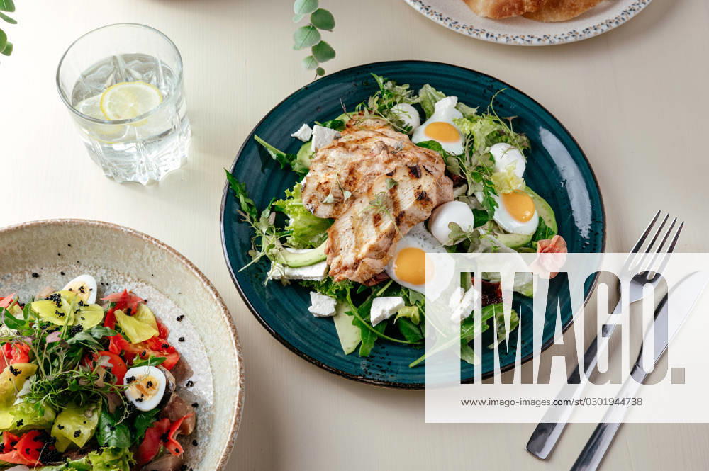 Warm salad with grilled chicken and egg . restaurant menu R_KUAL230815-1233869-01
