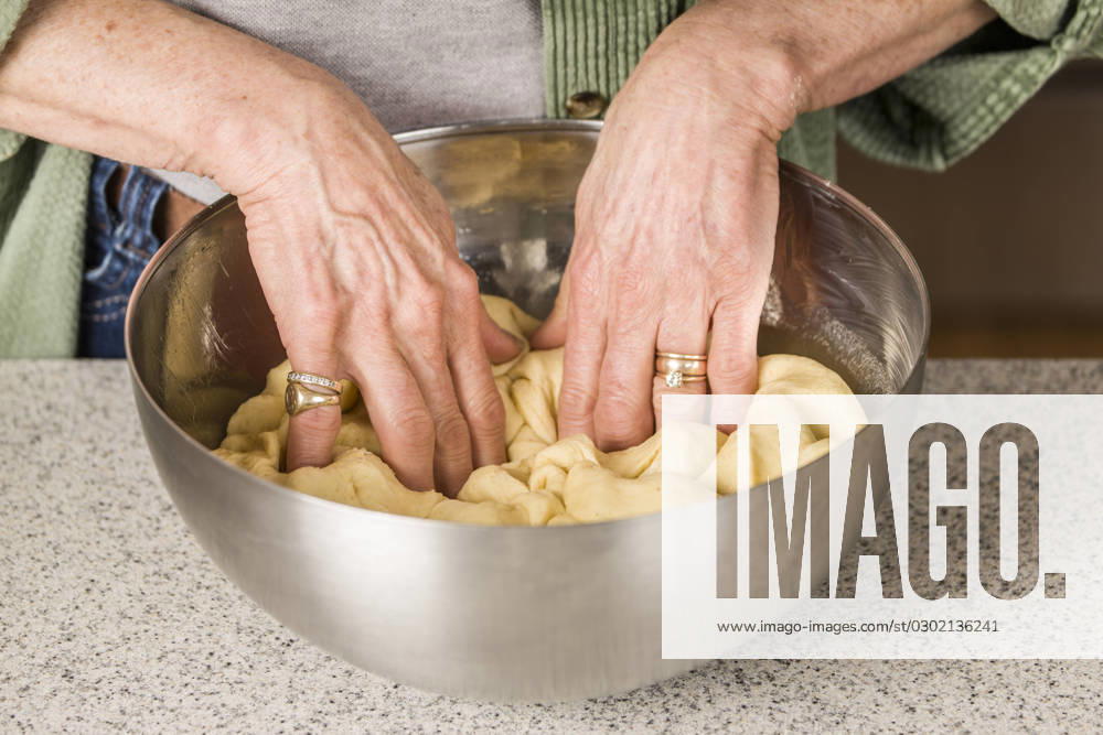 Woman punching down Monkey Bread dough, prior to forming it into balls. (MR)