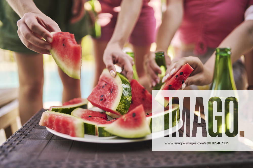Hands of friends holding slices of watermelon at table model released, Symbolfoto property released, ANNF00419