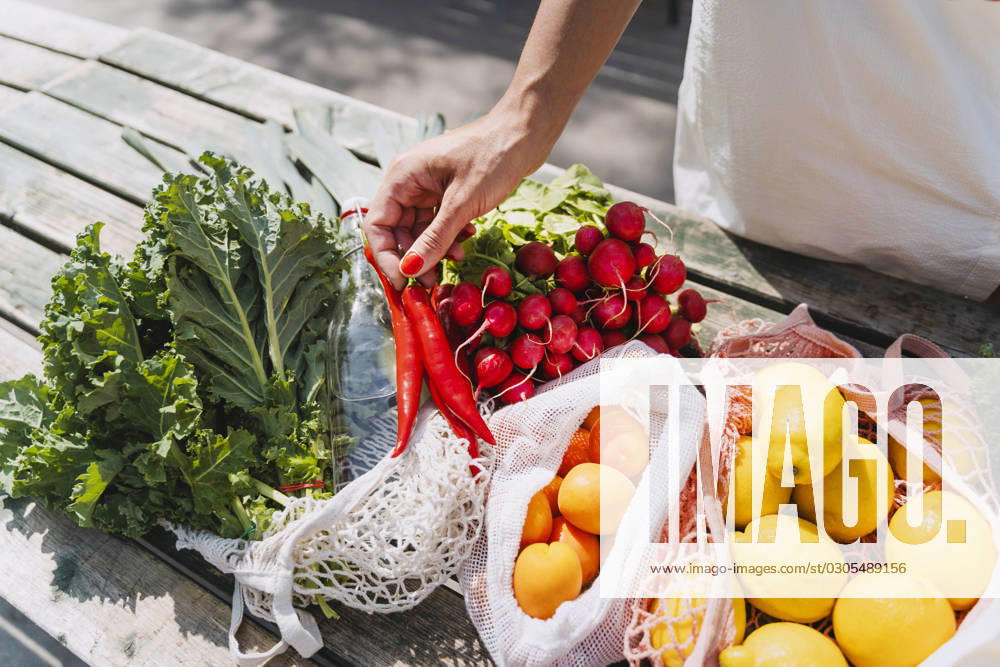 Woman holding red chilies and buying fresh vegetables in market model released, Symbolfoto, NDEF01000