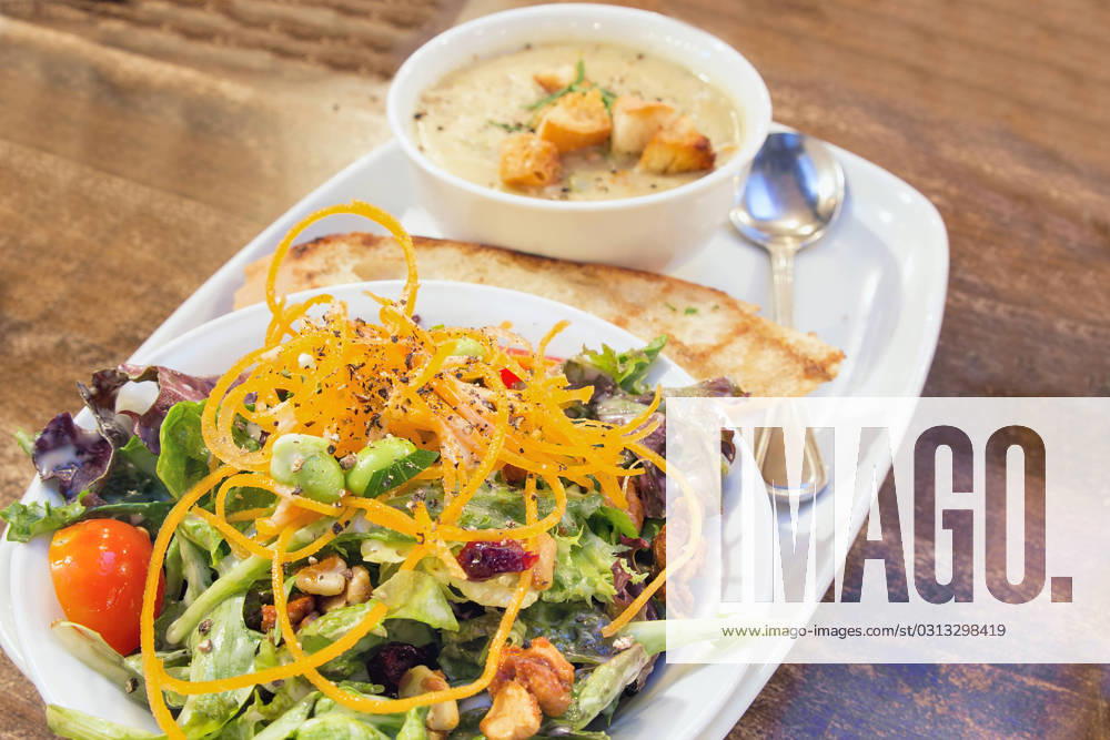 Spring Green Salad with Edamame Tomato Cashews Cranberries and Bowl of Corn Chowder Soup Closeup