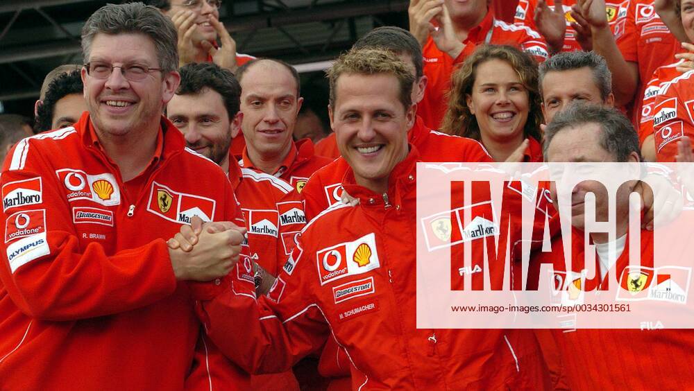 BRU467 - - FRANCORCHAMPS, BELGIUM : FROM L-R Technical director Ross Brawn, German pilot Michael Schumacher, French Director Jean Todt and the whole Ferrari team pose for a family picture after the Belgian Formula One Grand Prix, Sunday 29 August 2004, on the race track of Spa-Francorchamps. Finnish Kimi Raikkonen won the race and Michael Schumacher got World Champion for the 7th time. BENOITxDOPPAGNE x2141928x