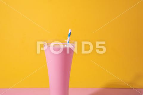 A glass of strawberry smoothie isolated on yellow and pink background fruit, diet, berry, strawberry, drink, healthy, nutrition, food, fresh, blended, vitamin, milkshake, background, summer, smoothie, sweet, dessert, refreshment, juicy, juice, glass, pink, isolated, straw, beverage, horizontal, yellow