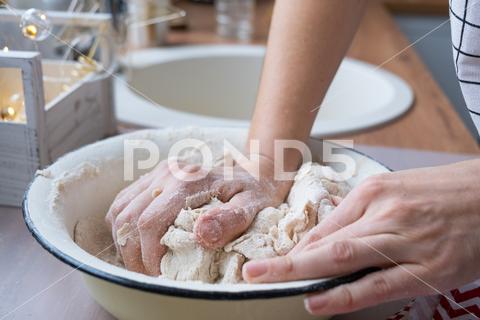 Hands knead thick dough on the kitchen table, decorated with festive decorations for Christmas and New year. Baking at home, aroma and comfort. Close-up knead, thick, dough, kitchen, table, Christmas, New year, Baking, home, aroma, comfort, Close up, Hands, flour, cookies, housewife, pizza, wheat, bread, mood, cozy, interior, decor, preparing, sculpt, woman, cook, lifestyle, dessert, cutting, form, prepare, knead, making, shape, raw, baker, recipe, kneading, cooking, pastry, sweet, winter, holiday, cookie, bake, preparation, bakery, homemade, food