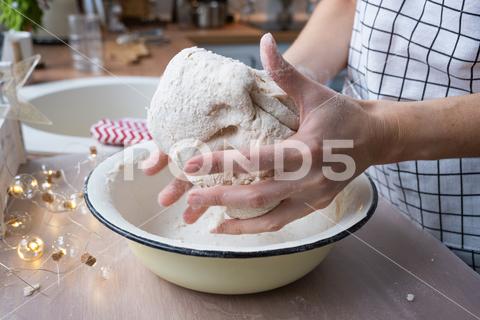 Hands knead thick dough on the kitchen table, decorated with festive decorations for Christmas and New year. Baking at home, aroma and comfort. Close-up knead, thick, dough, kitchen, table, Christmas, New year, Baking, home, aroma, comfort, Close up, Hands, flour, cookies, housewife, pizza, wheat, bread, mood, cozy, interior, decor, preparing, sculpt, woman, cook, lifestyle, dessert, cutting, form, prepare, knead, making, shape, raw, baker, recipe, kneading, cooking, pastry, sweet, winter, holiday, cookie, bake, preparation, bakery, homemade, food