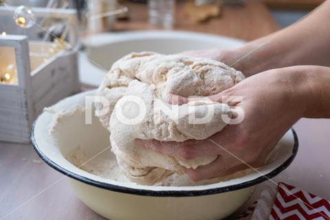 Hands knead thick dough on the kitchen table, decorated with festive decorations for Christmas and New year. Baking at home, aroma and comfort. Close-up knead, thick, dough, kitchen, table, Christmas, New year, Baking, home, aroma, comfort, Close up, Hands, flour, cookies, housewife, pizza, wheat, bread, mood, cozy, interior, decor, preparing, sculpt, woman, cook, lifestyle, dessert, cutting, form, prepare, knead, making, shape, raw, baker, recipe, kneading, cooking, pastry, sweet, winter, holiday, cookie, bake, preparation, bakery, homemade, food