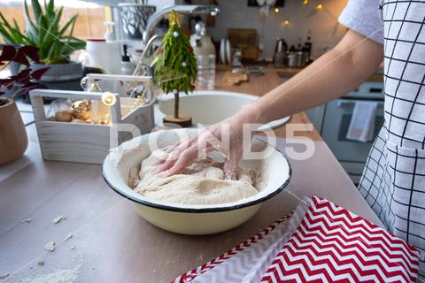 Hands knead thick dough on the kitchen table, decorated with festive decorations for Christmas and New year. Baking at home, aroma and comfort. Close-up knead, thick, dough, kitchen, table, Christmas, New year, Baking, home, aroma, comfort, Close up, Hands, flour, cookies, housewife, pizza, wheat, bread, mood, cozy, interior, decor, preparing, sculpt, woman, cook, lifestyle, dessert, cutting, form, prepare, knead, making, shape, raw, baker, recipe, kneading, cooking, pastry, sweet, winter, holiday, cookie, bake, preparation, bakery, homemade, food