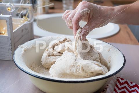Hands knead thick dough on the kitchen table, decorated with festive decorations for Christmas and New year. Baking at home, aroma and comfort. Close-up knead, thick, dough, kitchen, table, Christmas, New year, Baking, home, aroma, comfort, Close up, Hands, flour, cookies, housewife, pizza, wheat, bread, mood, cozy, interior, decor, preparing, sculpt, woman, cook, lifestyle, dessert, cutting, form, prepare, knead, making, shape, raw, baker, recipe, kneading, cooking, pastry, sweet, winter, holiday, cookie, bake, preparation, bakery, homemade, food