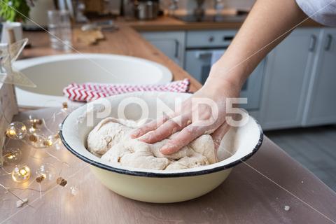 Hands knead thick dough on the kitchen table, decorated with festive decorations for Christmas and New year. Baking at home, aroma and comfort. Close-up knead, thick, dough, kitchen, table, Christmas, New year, Baking, home, aroma, comfort, Close up, Hands, flour, cookies, housewife, pizza, wheat, bread, mood, cozy, interior, decor, preparing, sculpt, woman, cook, lifestyle, dessert, cutting, form, prepare, knead, making, shape, raw, baker, recipe, kneading, cooking, pastry, sweet, winter, holiday, cookie, bake, preparation, bakery, homemade, food