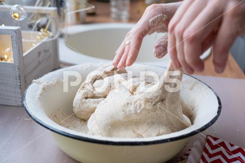 Hands knead thick dough on the kitchen table, decorated with festive decorations for Christmas and New year. Baking at home, aroma and comfort. Close-up knead, thick, dough, kitchen, table, Christmas, New year, Baking, home, aroma, comfort, Close up, Hands, flour, cookies, housewife, pizza, wheat, bread, mood, cozy, interior, decor, preparing, sculpt, woman, cook, lifestyle, dessert, cutting, form, prepare, knead, making, shape, raw, baker, recipe, kneading, cooking, pastry, sweet, winter, holiday, cookie, bake, preparation, bakery, homemade, food