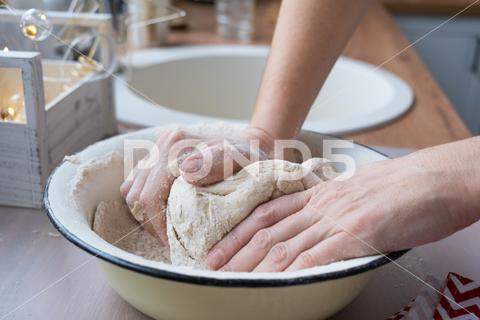Hands knead thick dough on the kitchen table, decorated with festive decorations for Christmas and New year. Baking at home, aroma and comfort. Close-up knead, thick, dough, kitchen, table, Christmas, New year, Baking, home, aroma, comfort, Close up, Hands, flour, cookies, housewife, pizza, wheat, bread, mood, cozy, interior, decor, preparing, sculpt, woman, cook, lifestyle, dessert, cutting, form, prepare, knead, making, shape, raw, baker, recipe, kneading, cooking, pastry, sweet, winter, holiday, cookie, bake, preparation, bakery, homemade, food