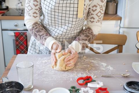 Hands knead thick dough on the kitchen table, decorated with festive decorations for Christmas and New year. Baking at home, aroma and comfort. Close-up knead, thick, dough, kitchen, table, christmas, flour, new year, baking, molds, cookies, snowman, home, aroma, comfort, hands, housewife, bakery, wheat, bread, mood, cozy, interior, decor, preparing, sculpt, woman, cook, homemade, dessert, cutting, form, prepare, making, shape, raw, baker, recipe, kneading, cooking, pastry, sweet, winter, holiday, cookie, bake, eating, hand, cuisine