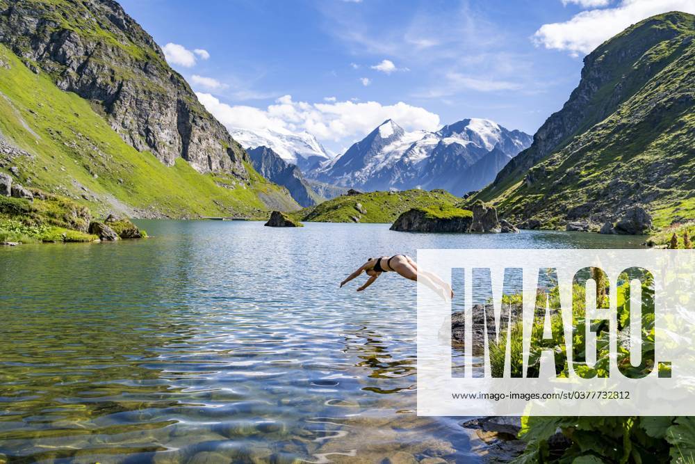 Pike jump, Boy Woman with Bikini jumps ins clear Water one picturesque mountain lake, Lac de Louvie, Grand Combin, Valaisan Alps, Wallis, Switzerland, Europe