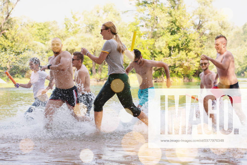 Summer joy friends having fun on river summer joy group of happy friends having fun while running and splashing on river ,model released, Symbolfoto