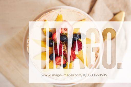 An overhead shot of delicious mango strawberry summer naked cake on a white table with white background 607004 RECORD DATE NOT STATED