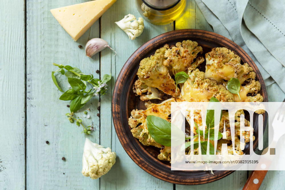Healthy eating, plant based meat substitute concept.Vegetarian organic food. Baked cauliflower steaks with herbs and spices on a wooden table. View from above. Healthy eating, plant based meat substitute concept.Vegetarian organic food. Baked cauliflower steaks with herbs and spices on a wooden table. View from above.