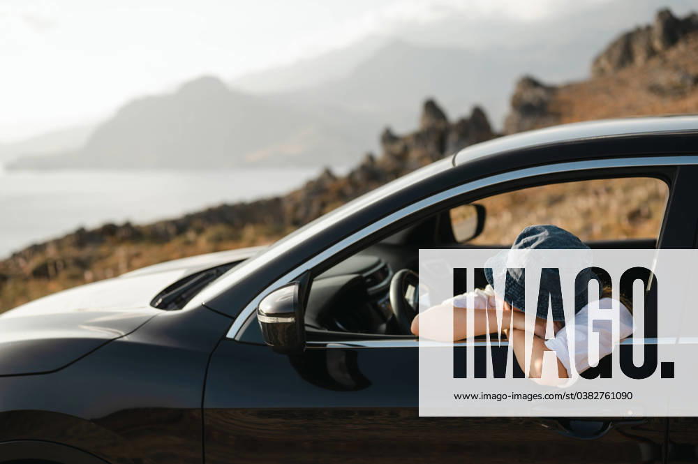 Young woman leaning on car window looking at coastal landscape Foinikas, Greece R_AKAO240102E3-1313979-01 ,model released, Symbolfoto
