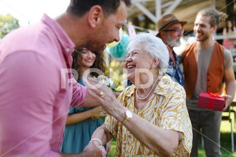 Garden birthday party for senior lady. Beautiful senior birthday woman receiving birthday wishes and gifts. birthday woman senior hugging gifts garden birthday party beautiful woman lady receiving gift wishes embrace smile friends family grandmother grandson celebration joy happiness presents outdoors event festivity gathering special occasion surprise smiles enjoyment togetherness love affection decorations cake memories balloons laughter congratulations entertainment bonding delight cheerful atmosphere friendship gratitude copy space gray hair pearls