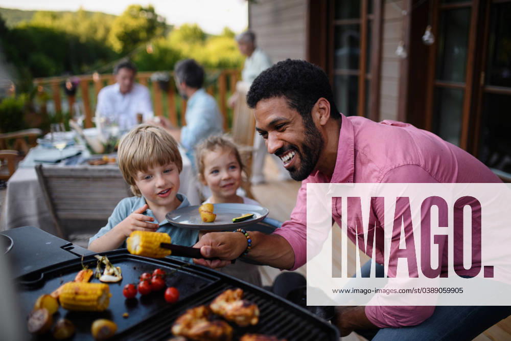 Multi generation family having bbq party outside in the backyard on patio. Multi generation family having party outside in the backyard on a patio. model released