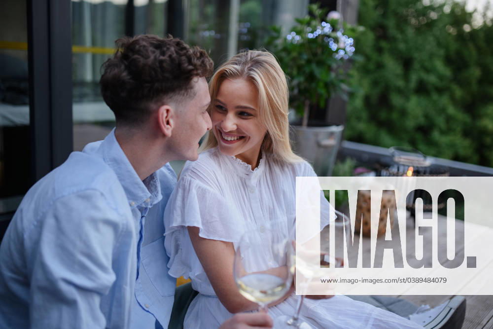 Young couple clinking with wine outdoors, weekend away in tiny house in countryside, sustainable living. A young couple clinking with wine outdoors, weekend away in tiny house in countryside, sustainable living. model released