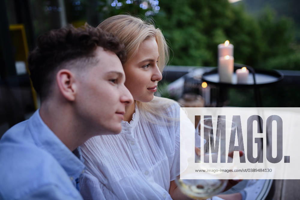 Young couple clinking with wine outdoors, weekend away in tiny house in countryside, sustainable living. A young couple clinking with wine outdoors, weekend away in tiny house in countryside, sustainable living. model released