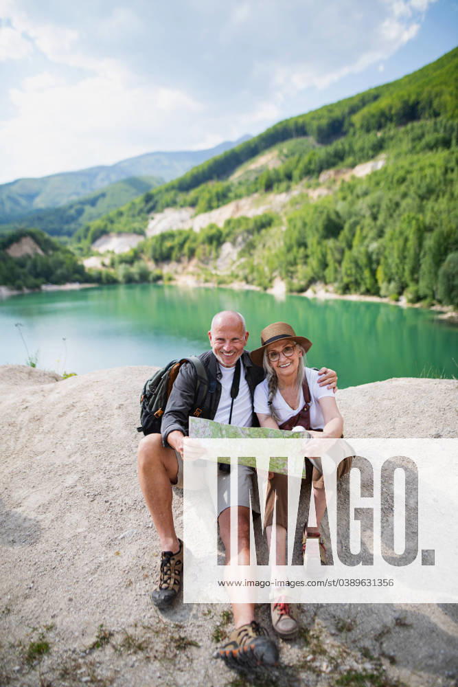Happy senior couple on hiking trip on summer holiday, using map. A happy senior couple on hiking trip on summer holiday, using map. model released