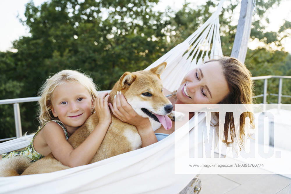 Smiling mother and daughter petting Shiba Inu dog in hammock model released, Symbolfoto property released, NJAF00702