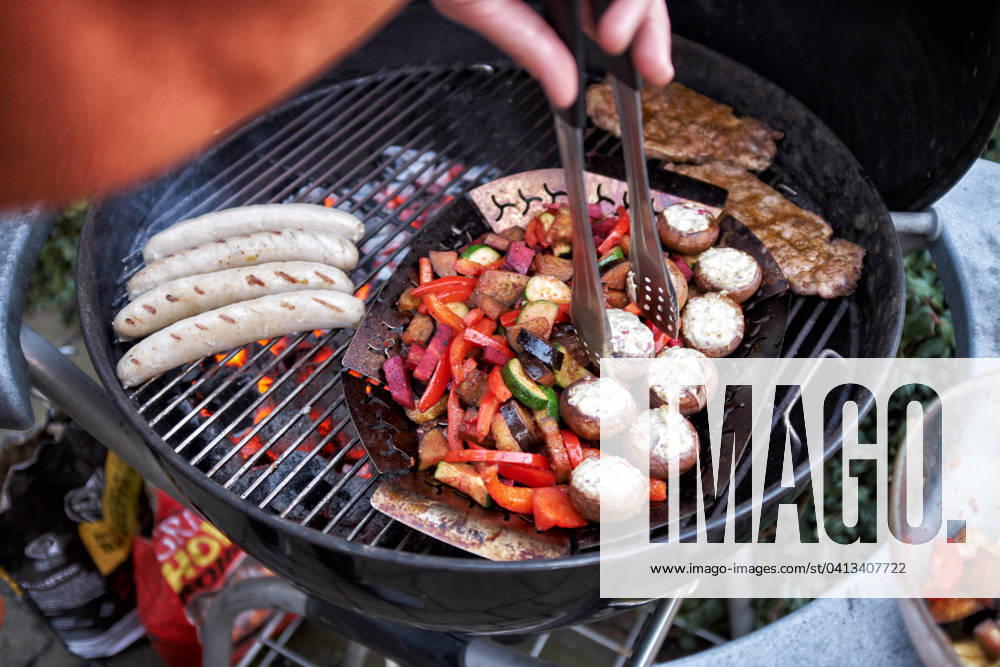 Barbecue at a Round grill become simultaneously Sausages, Steaks and Vegetables grilled Food NRW