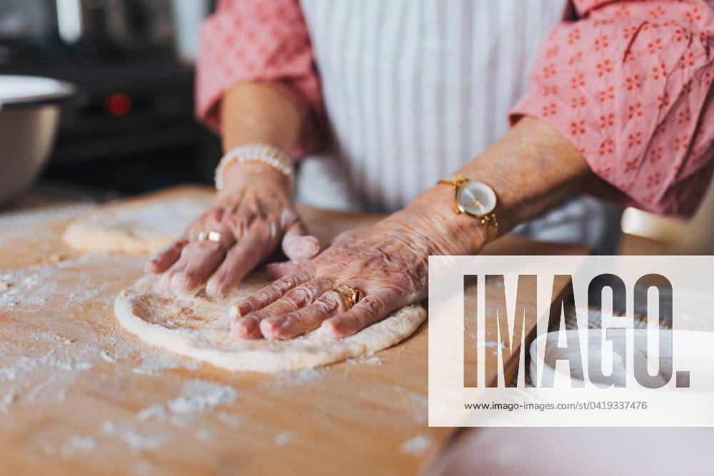 Close up of hands of senior woman preparing traditional easter meals for family, kneading dough for easter cross buns. Recreating family recipes, custom. Close up of hands of senior woman preparing traditional easter meals for family, kneading dough for easter cross buns. Recreating family recipes, custom. Concept of easter holidays and traditions. model released