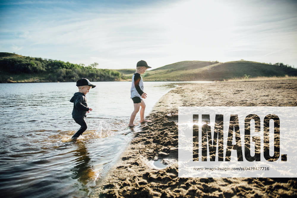 Side view of two young boys playing in a lake on a summer evening. Bismarck, North Dakota, United States CR_KIFR240228-1358305-01 ,model released, Symbolfoto