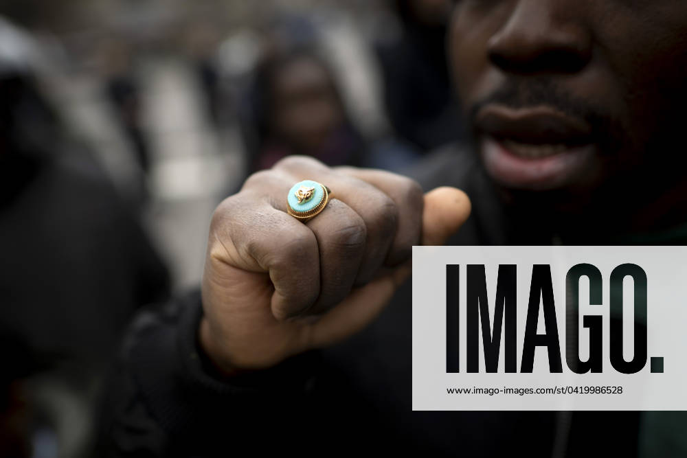 Gedenkmarsch Kolonialgeschichte DEU, Deutschland, Germany, Berlin, 25.02.2024 Demonstrant mit Faust und Ring als Symbol der African Black Community beim 17. Gedenkmarsch zur Erinnerung an die afrikanischen und schwarzen Opfer von Versklavung Kolonialismus und rassistischer Gewalt Maafa vom Komitee fuer die Errichtung fuer ein afrikanisches Denkmal Kadib in Berlin in Berlin Deutschland . Forderung nach Anerkennung der Verbrechen gegen Schwarze Menschen und Menschen afrikanischer Herkunft unter Einfluss der Black Lives Matter Bewegung. Mehr als 30 Millionen Afrikanerinnen und Afrikaner wurden Opfer von Versklavung und kolonialen Verbrechen. Die von Deutschland an den Herero und Nama begangenen Voelkermorde in Namibia und die Kriegsverbrechen
