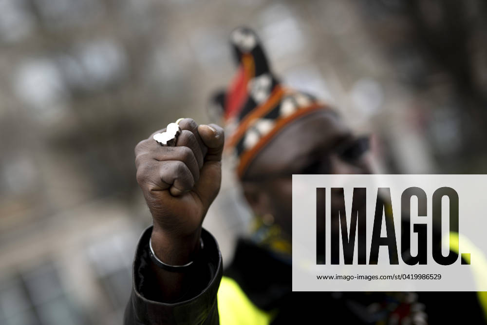 Gedenkmarsch Kolonialgeschichte DEU, Deutschland, Germany, Berlin, 25.02.2024 Demonstrant mit Faust und Ring in Form von Afrika als Symbol der African Black Community beim 17. Gedenkmarsch zur Erinnerung an die afrikanischen und schwarzen Opfer von Versklavung Kolonialismus und rassistischer Gewalt Maafa vom Komitee fuer die Errichtung fuer ein afrikanisches Denkmal Kadib in Berlin in Berlin Deutschland . Forderung nach Anerkennung der Verbrechen gegen Schwarze Menschen und Menschen afrikanischer Herkunft unter Einfluss der Black Lives Matter Bewegung. Mehr als 30 Millionen Afrikanerinnen und Afrikaner wurden Opfer von Versklavung und kolonialen Verbrechen. Die von Deutschland an den Herero und Nama begangenen Voelkermorde in Namibia und di