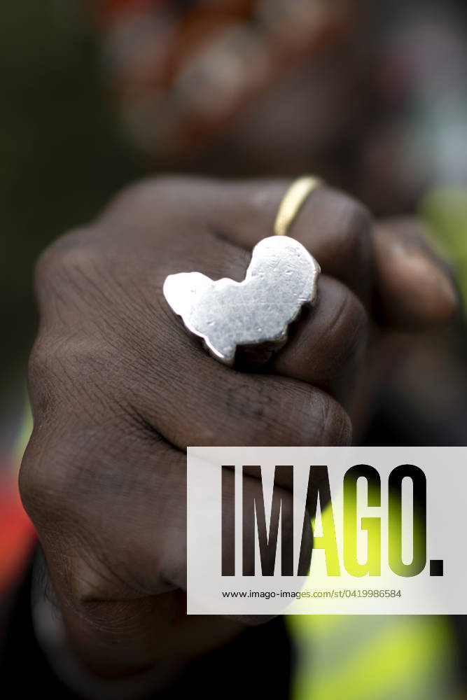 Gedenkmarsch Kolonialgeschichte DEU, Deutschland, Germany, Berlin, 25.02.2024 Demonstrant mit Faust und Ring in Form von Afrika als Symbol der African Black Community beim 17. Gedenkmarsch zur Erinnerung an die afrikanischen und schwarzen Opfer von Versklavung Kolonialismus und rassistischer Gewalt Maafa vom Komitee fuer die Errichtung fuer ein afrikanisches Denkmal Kadib in Berlin in Berlin Deutschland . Forderung nach Anerkennung der Verbrechen gegen Schwarze Menschen und Menschen afrikanischer Herkunft unter Einfluss der Black Lives Matter Bewegung. Mehr als 30 Millionen Afrikanerinnen und Afrikaner wurden Opfer von Versklavung und kolonialen Verbrechen. Die von Deutschland an den Herero und Nama begangenen Voelkermorde in Namibia und di