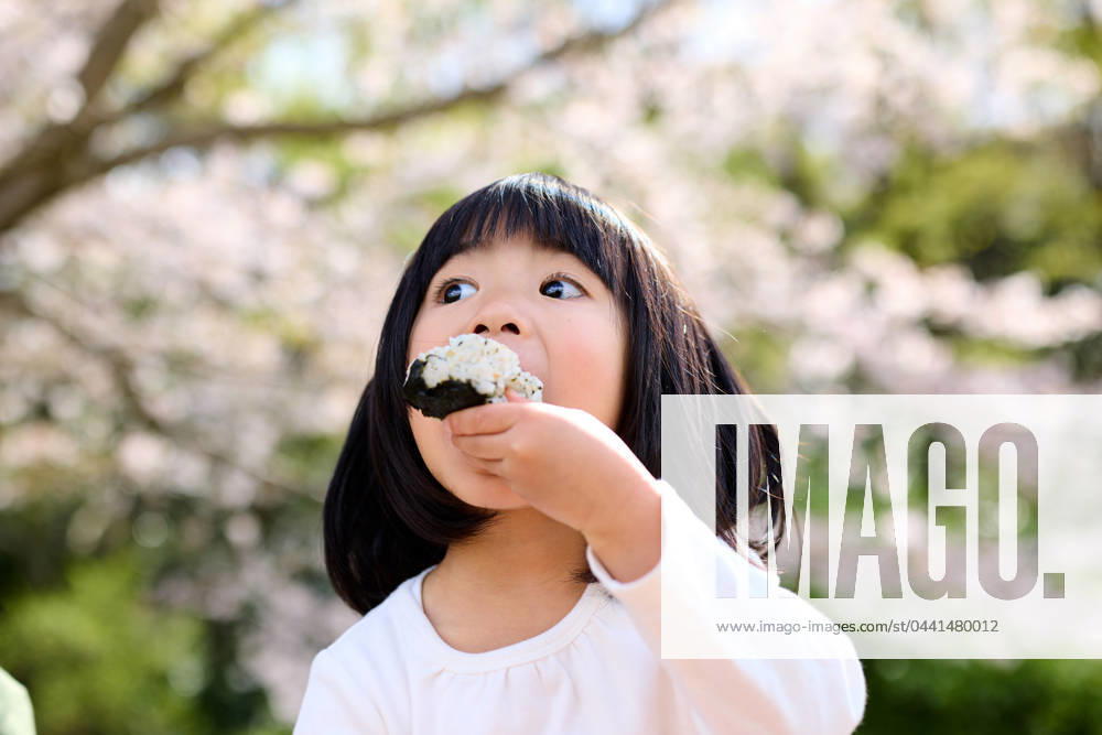 IMAGO Creative, Food, Japan, Onigiri A little girl eating a rice ball AFLO235682899 , 235682899.jpg, ,model released, Symbolfoto