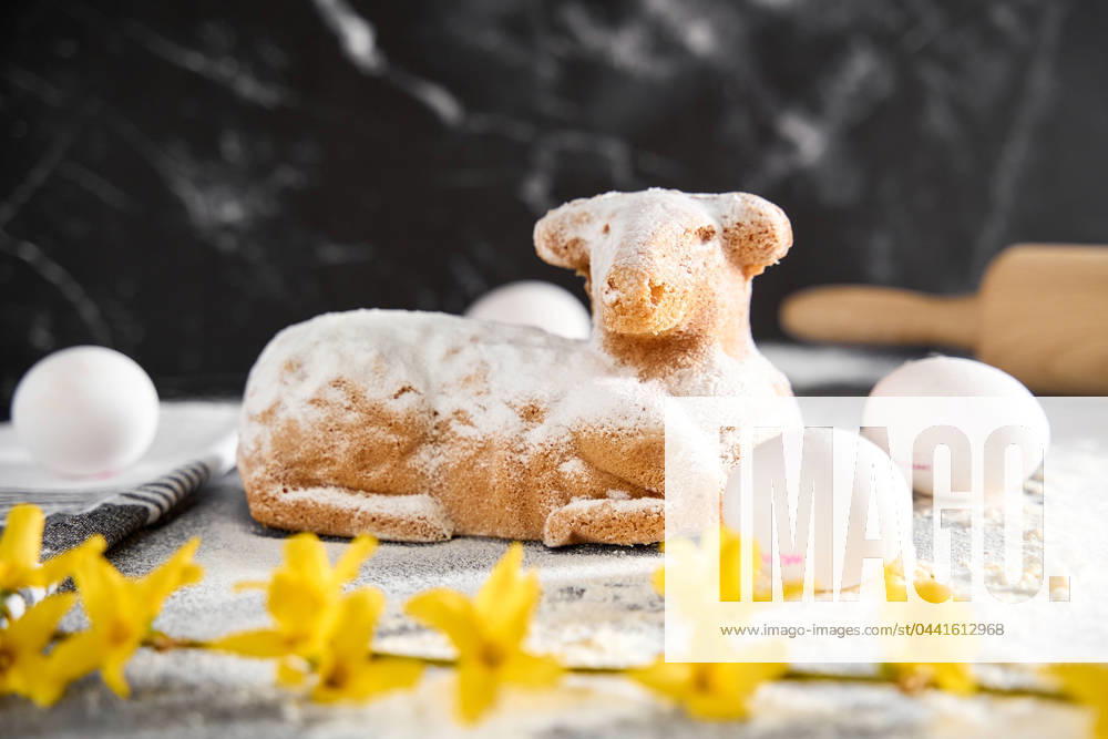 Traditional Easter lamb as a cake for Easter. Baking concept with flour, eggs and fresh yellow flowers