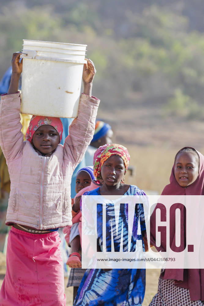 Girl carrying a heavy water bucket on her head, Maraban Dare, 07 02 2024 Maraban Dare Nigeria