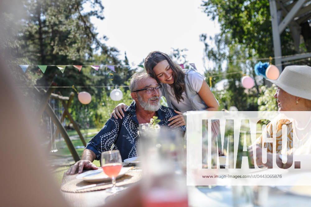 Mature granddaughter talking with grandparents, reunite after a long time. Family gathering at garden party. Mature granddaughter talking with grandparents, reunite after a long time. Family gathering at a garden party. model released