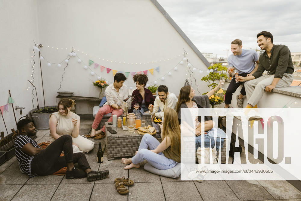 Group of multiracial friends having fun while celebrating during party in decorated balcony Germany, Berlin, model released, property released