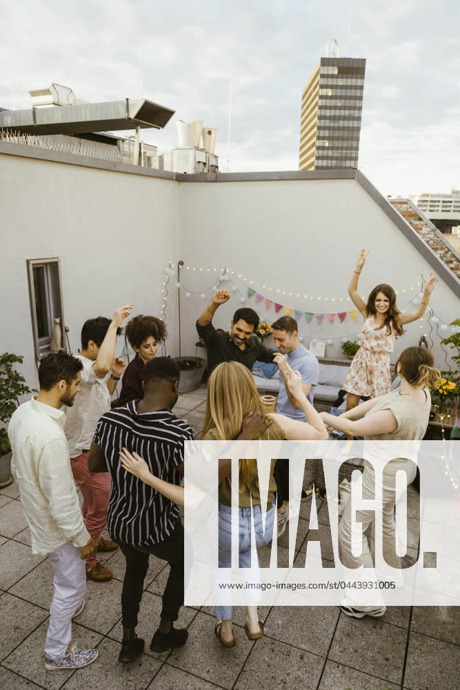 Group of friends dancing on rooftop deck at party Germany, Berlin, model released, property released
