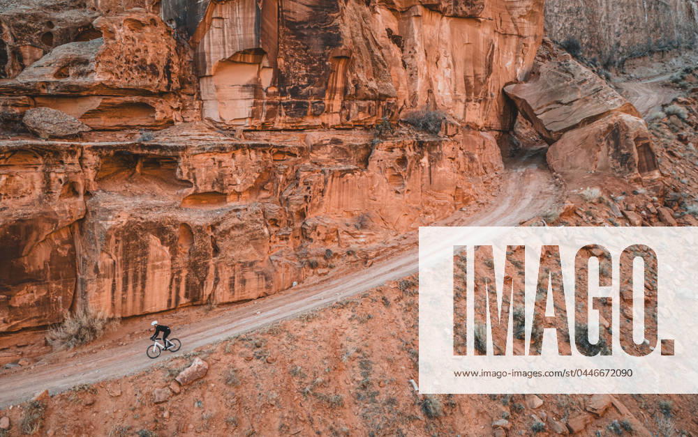 Man rides bike down narrow dirt road on cliff face, Moab, Utah Moab, Utah, United States CR_SSNF240416E-1380705-01 ,model released, Symbolfoto