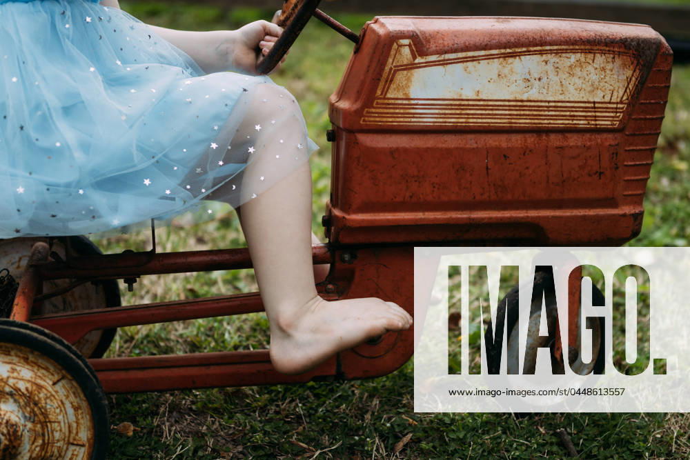 IMAGO Creative: Sommer, Sommertage im Garten Child riding vintage pedal tractor toy in yard McClure, Illinois, United States R_WEKW240423-1409192-01 ,model released, Symbolfoto