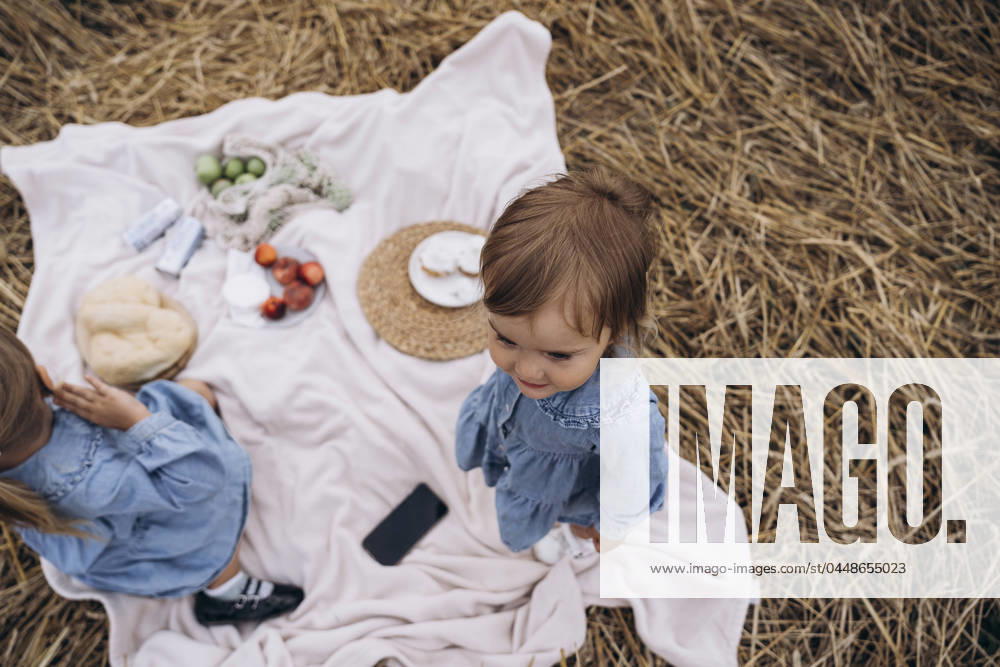 Sisters in denim dresses on picnic blanket model released, Symbolfoto, KANF00042