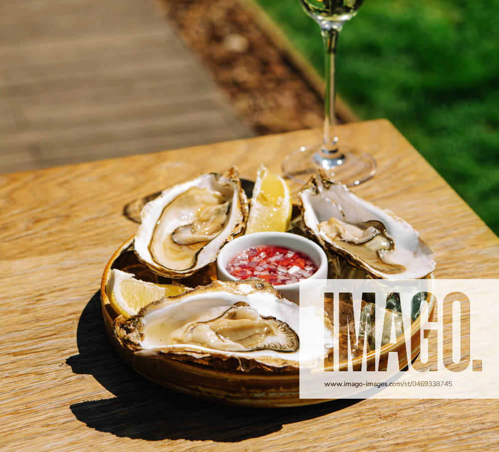 Opened oysters and lemon with white wine on the table Opened oysters and lemon with white wine on the table