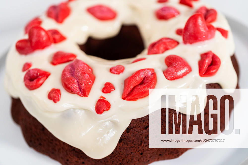 Red velvet bundt cake Freshly baked red velvet bundt cake with chocolate lips and hearts over cream cheese glaze for Valentine s Day.
